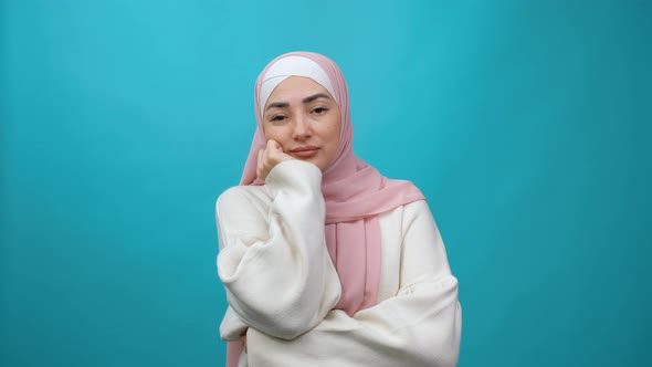 Lazy Sleepy Young Muslim Woman in Hijab Standing Leaning on Hand Looking at Camera with Bored