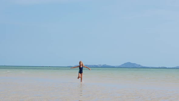 6Yearold Girl Runs Into the Distance in Shallow Water alt