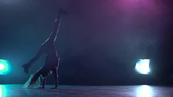 Little Child Does a Handstand in the Studio. Multicolor Smoke Background. Silhouette. Light From alt