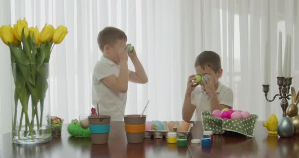 Two Little Brothers Jump Like Bunnies with Colored Eggs in Their Eyes alt