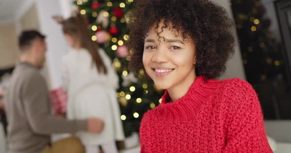 Portrait of African woman and her family in the background alt