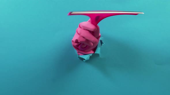 A Hand in a Pink Rubber Glove Holds a Plastic Window Cleaner a Ragged Hole