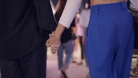 A Close Up Shot of a Lesbian Couple Holding Each Other's Hands Walking Down the Street alt