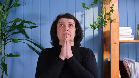 Middle Aged Woman Praying at Home