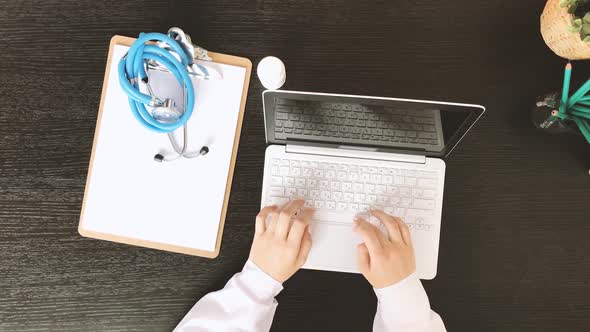 Top View of Female Doctor Hands Typing on Laptop