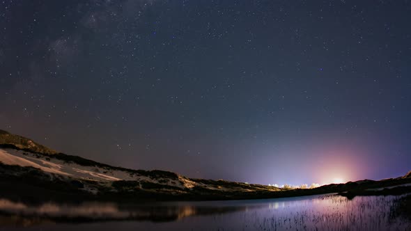 Time Lapse 4K - Stars over the dunes and reflections on the lake.