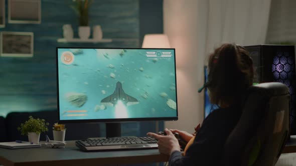 Back Shot of Pro Gamer Playing Online Space Shooter Game on Powerful Computer alt