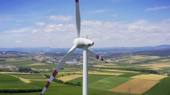 Aerial flight near wind turbines. Farm landscape. Clear renewable energy production.