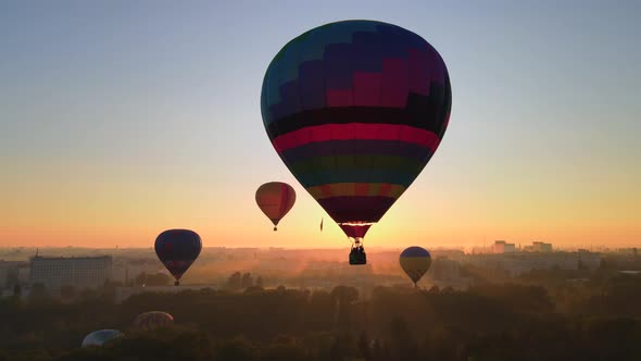 Aerial Drone View Silhouette of Colorful Hot Air Balloon Flying Over Green Park in Small European alt