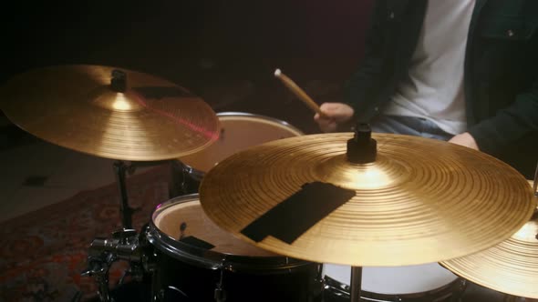 Drummer Playing the Drum Set in a Dark Room on a Black Background alt