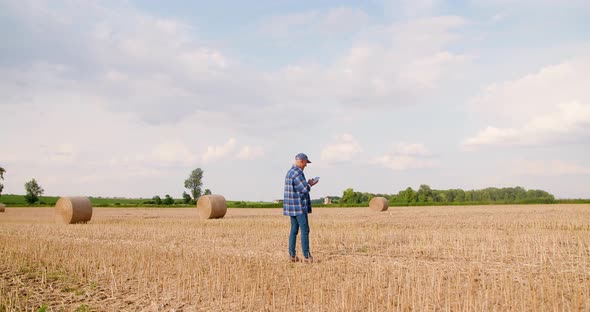Farmer Using Digital Tablet While Examining Field alt