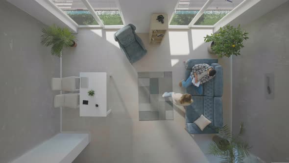 Man sitting on sofa and woman coming