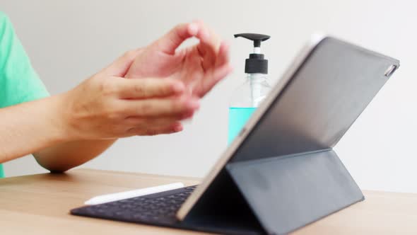 Asian woman using alcohol gel sanitizer wash hand before using tablet for protect coronavirus. alt