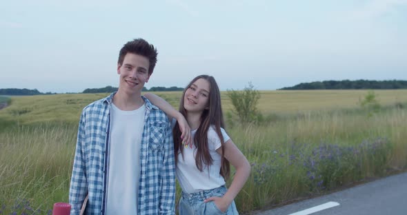Portrait of Young Girl Poses Leans on Male Shoulder and They Smile at Camera alt