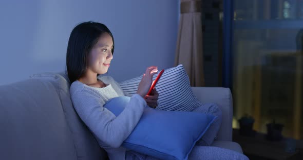 Woman look at mobile phone at home alt