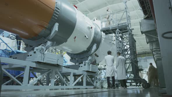 Two Scientist Engineers Inspect the Spacecraft Write on the Tablet alt