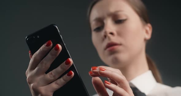 Vexed and Dissatisfied European Woman Swipes the Screen of Smartphone in a Rush Angry Office Worker alt