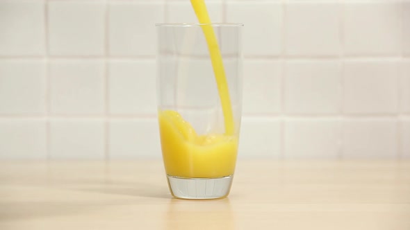 Pouring orange juice into a glass alt