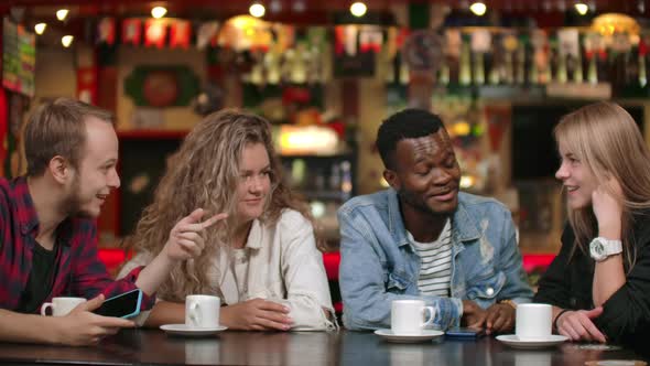 Multinational Group of Man and Woman Sitting Together at a Table with Cups of Coffee, Smiling alt