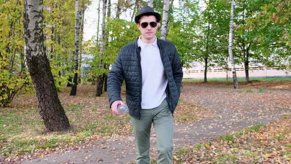 Slow motion video of a young man throwing a plastic bottle in the trash. Close up. 4k alt