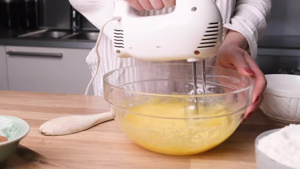 Whisking Eggs On Bowl With Handheld Electric Mixer For Baking A Carrot Cake. - close up alt