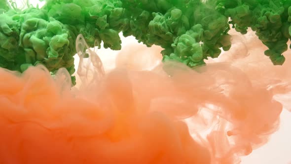 Green and Orange Acrylic Ink in Water on White Background. Abstract Background. alt