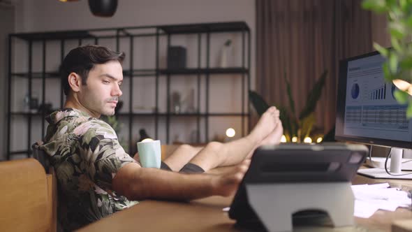 Young man sitting at home working in a relax and comfortable posture.