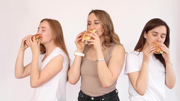 Three Girls Eating Delicious Burgers.