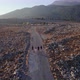 Four young tourists walking along empty rocky rural road in the countryside - VideoHive Item for Sale