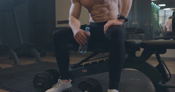Exhausted Young Men Resting After Intensive Workout at Bench in Gym alt
