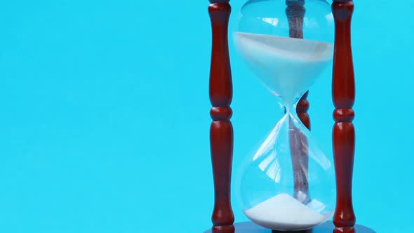 Time passing metaphor. Sand falling down in hourglass