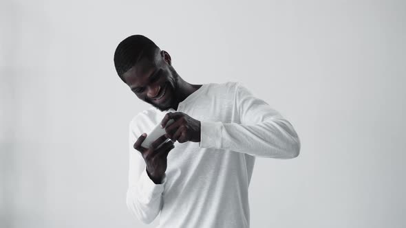 Mobile Gaming African Winner Guy Playing on Phone alt