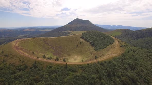 Aerial travel drone view of the Puy de Dome, lava dome volcano in France. alt