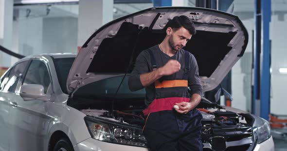 Charismatic Mechanic Guy in a Uniform Stand Over  alt