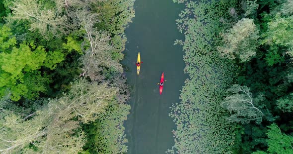 Two kayaks are sailing along a scenic river. Aerial view.