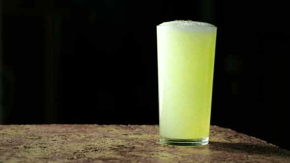 Carbonated Soda Drink, Yellow in Color and Poured Into a Glass on a Black Background.