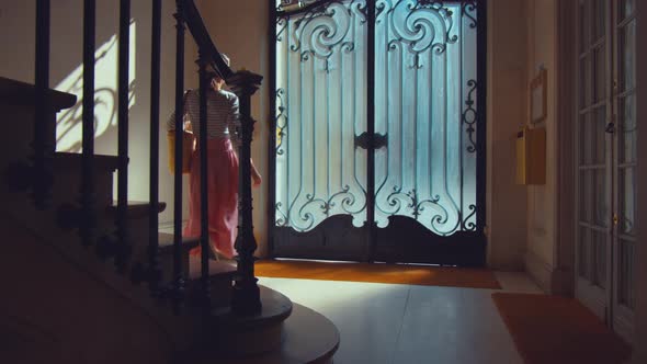Attractive girl coming out of a vintage door in the porch alt