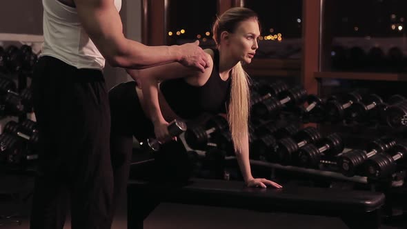 The Coach Controls How the Woman Performs the Exercise with Dumbbells alt