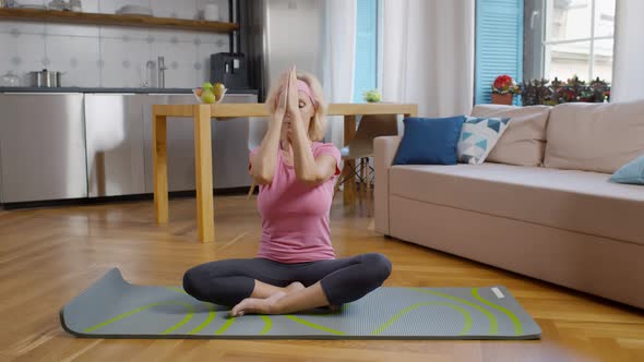 Mature Female Meditating in Lotus Pose at Home alt
