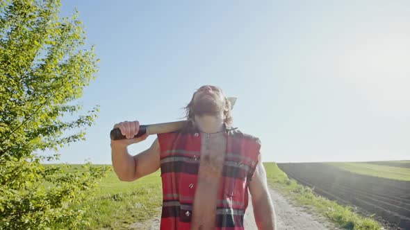 Lumberjack Worker Walking in the Farmland on a Sunny, Warm Summer Day alt