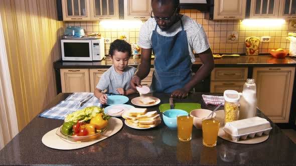 African American man showing his son how to do sandwich