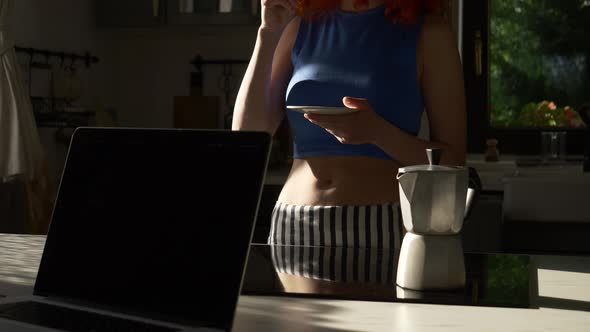 woman with cup of coffee in kitchen at home