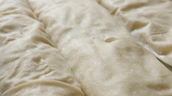 Rolls of homemade filo pie with cheese and spinach 4K 2160p 30fps UHD tilting footage - Thin sheets  alt