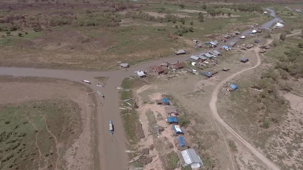Aerial view of small boat sailing on mud canal, Tonle Sap, Cambodia. alt