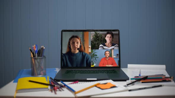 A Young Woman is Talking on a Video Call with a Young Man and a Woman