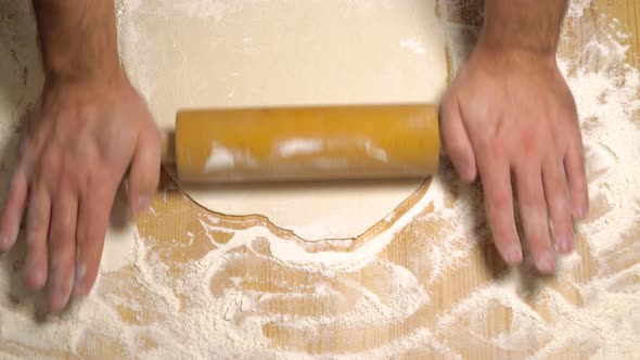 Top View of Man Hands Rolling Dough on Table