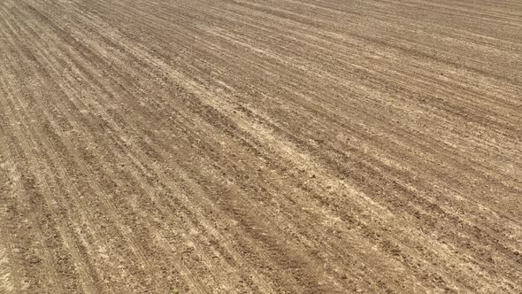 Slow flying over the fertile soil after plowing 4K drone video alt