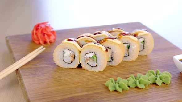 Rolls Served on Wooden Board with Wasabi Red Ginger and Soy Sauce