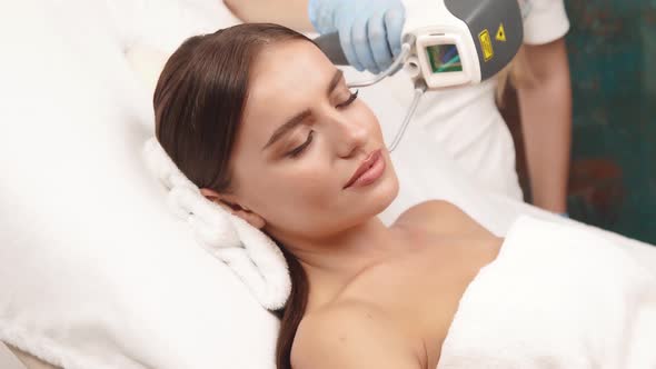 Cosmetologist Working on Female Face with Professional Laser alt