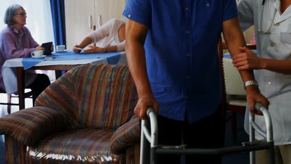 Female doctor assisting senior man to walk with folding walkers 4k alt